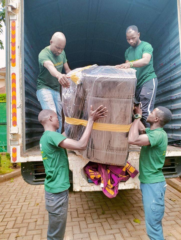 Hi-vis crew loading wrapped furniture into a truck