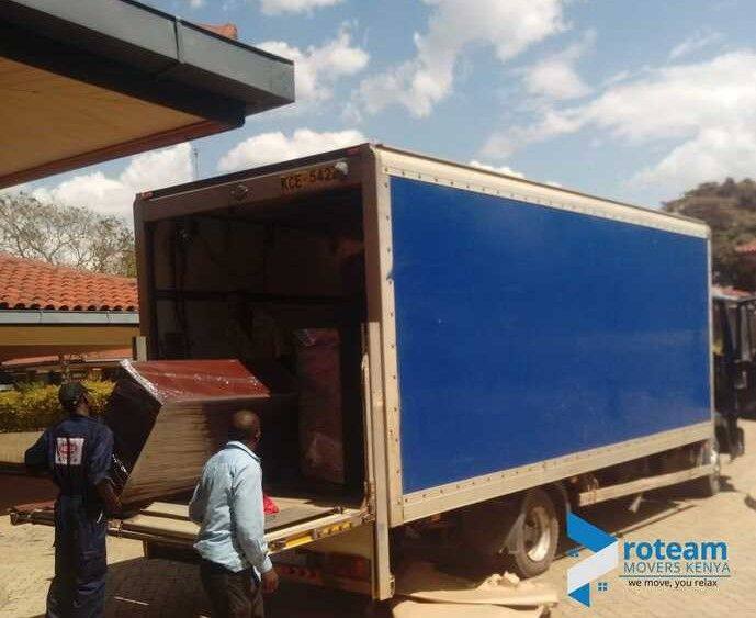 Movers loading furniture into a blue box truck